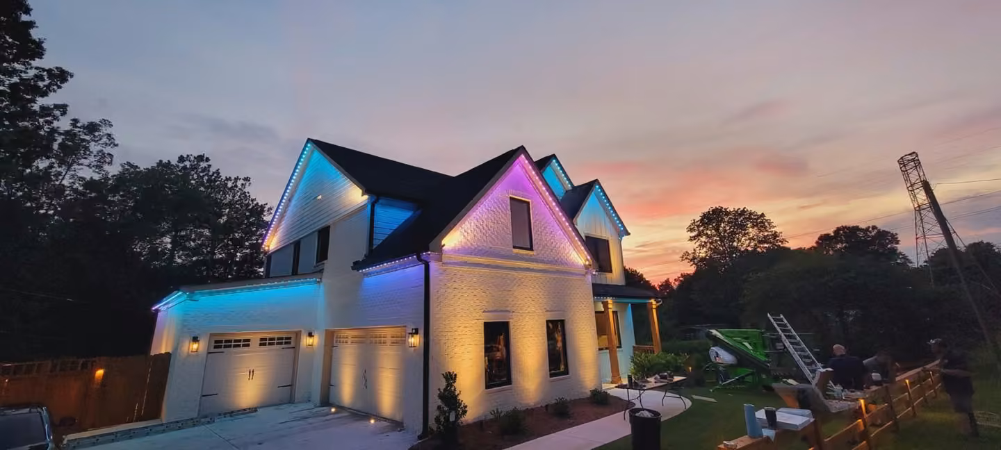 Permanent lighting highlights the rooflines of a Colorado-style home in blue, pink and warm white