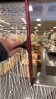 A squeegee clears soapy glass at the entrance to a store